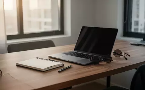Ein minimalistischer Schreibtisch mit Laptop und Sonnenbrille in natürlichem Tageslicht. - Foto: über boerse-global.de