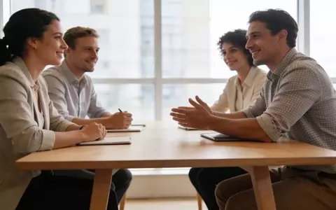 Geschäftsleute in einem modernen, hellen Büro bei einem professionellen Treffen an einem Konferenztisch. - Foto: über boerse-global.de
