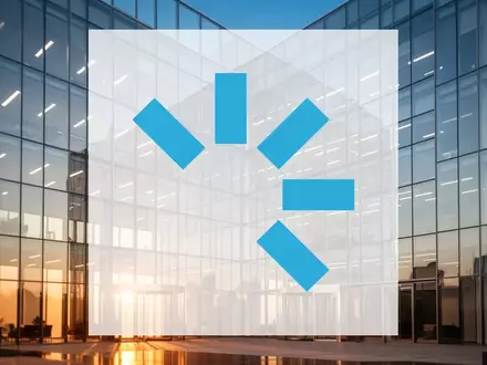 Moderne Glasfassade eines Bürogebäudes bei Sonnenuntergang als Symbol für Unternehmenswachstum und regulatorische Genehmigung - Foto: über boerse-global.de