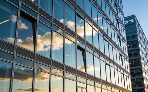 Ein modernes Bürogebäude mit Glasfassade bei Tageslicht. - Foto: über boerse-global.de