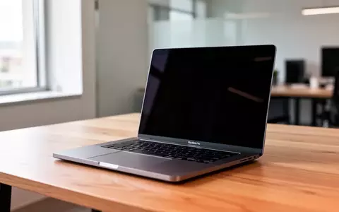Ein aufgeklapptes MacBook Pro auf einem minimalistischen Schreibtisch in einem hellen, modernen Büro. - Foto: über boerse-global.de