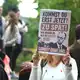 Demonstranten warfen Merz vor, erst nach Ende der Löscharbeiten den Brandort aufzusuchen.  - Bild: Christoph Reichwein/dpa