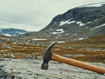 Ein geologischer Feldhammer auf felsigem Untergrund in einer abgelegenen arktischen Landschaft. - Foto: über boerse-global.de