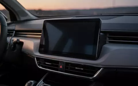 Nahaufnahme eines modernen Auto-Infotainment-Bildschirms in einem dunklen Fahrzeuginnenraum bei Dämmerung. - Foto: über boerse-global.de