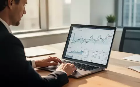Ein Finanzanalyst betrachtet abstrakte Kursverläufe an einem Laptop in einem hellen, modernen Büro. - Foto: über boerse-global.de