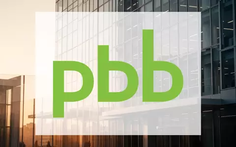 Moderne Glasfassade eines Finanzgebäudes im goldenen Licht als Symbol für Stabilität und institutionelles Bankwesen. - Foto: über boerse-global.de