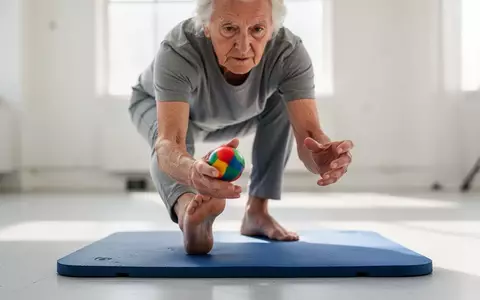 Eine Person trainiert Gleichgewicht und Koordination durch eine Übung, bei der sie gleichzeitig balanciert und einen Ball hält. - Foto: über boerse-global.de