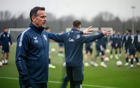 Ein Fußballtrainer bei einer Trainingseinheit auf dem Spielfeld während einer taktischen Besprechung. - Foto: über boerse-global.de
