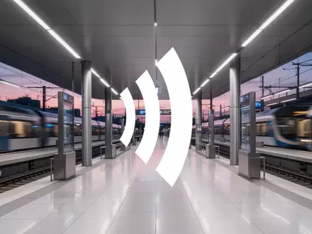 Moderne Bahnhofsarchitektur mit unscharfen Zügen als Symbol für Infrastruktur und öffentliche Verkehrsmittel. - Foto: über boerse-global.de