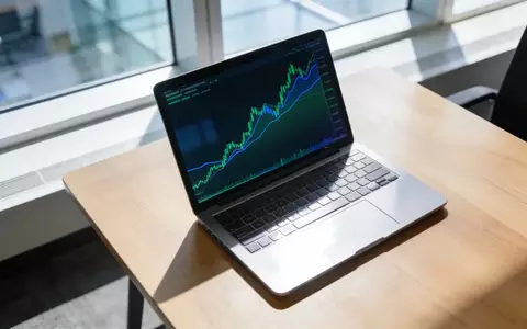 Ein moderner, heller Büroarbeitsplatz mit einem Laptop, auf dem abstrakte Finanzkurse zu sehen sind. - Foto: über boerse-global.de
