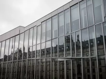 Moderne Glasfassade eines deutschen Gerichtsgebäudes an einem bewölkten Tag. - Foto: über boerse-global.de