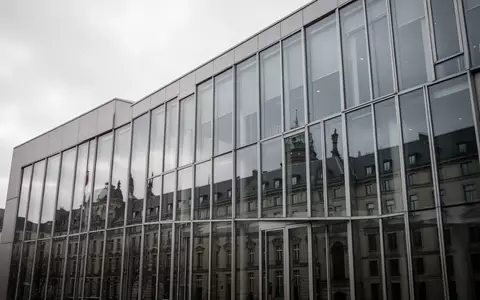 Moderne Glasfassade eines deutschen Gerichtsgebäudes an einem bewölkten Tag. - Foto: über boerse-global.de
