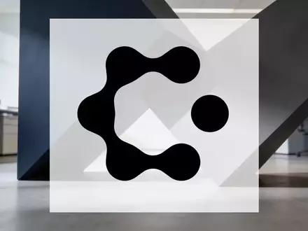 Abstrakte Darstellung einer Unternehmensfusion durch ineinandergreifende geometrische Formen in einem modernen Büro. - Foto: über boerse-global.de