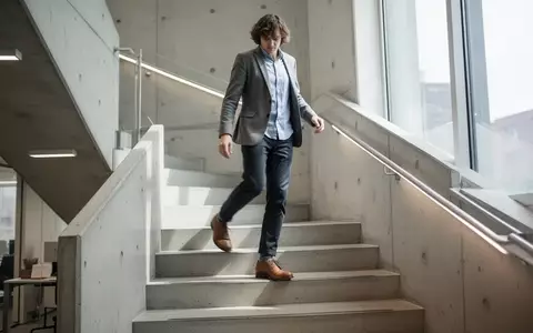 Eine Person in Business-Kleidung beim Treppensteigen in einem modernen Bürogebäude bei Tageslicht. - Foto: über boerse-global.de