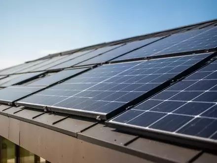 Moderne Hybrid-Solarmodule auf einem Hausdach an einem sonnigen Sommertag zur effizienten Temperaturregulierung. - Foto: über boerse-global.de