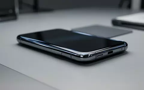 Ein minimalistischer Smartphone-Prototyp mit gebogenem Glasdesign liegt auf einem sauberen Arbeitstisch. - Foto: über boerse-global.de