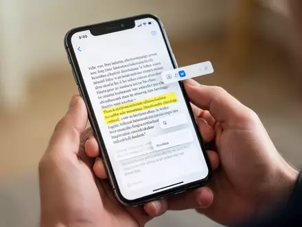 Nahaufnahme einer Hand, die ein Smartphone hält, auf dessen Display ein Textabschnitt markiert ist. - Foto: über boerse-global.de