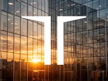 Moderne Glasfassade eines Bürogebäudes bei Sonnenaufgang als Symbol für den Immobiliensektor - Foto: über boerse-global.de