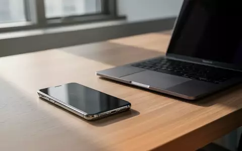 Modernes Büroarbeitszimmer mit Smartphone und Laptop auf einem Schreibtisch bei natürlichem Tageslicht. - Foto: über boerse-global.de