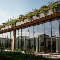 Modernes, nachhaltiges Bürogebäude mit extensiver Dachbegrünung und großflächigen Glasfassaden bei natürlichem Tageslicht. - Foto: über boerse-global.de