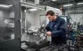 Ein Facharbeiter an einer modernen CNC-Maschine in einer Werkstatt für Feinwerktechnik. - Foto: über boerse-global.de
