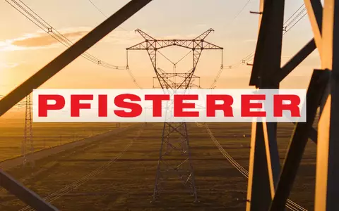 Moderne Hochspannungsmasten in einer weitläufigen Landschaft während des Sonnenuntergangs als Symbol für Energieinfrastruktur. - Foto: über boerse-global.de
