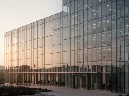 Moderne Bürogebäude mit Glasfassade im sanften Licht der goldenen Stunde. - Foto: über boerse-global.de