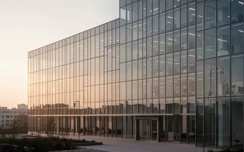 Moderne Bürogebäude mit Glasfassade im sanften Licht der goldenen Stunde. - Foto: über boerse-global.de