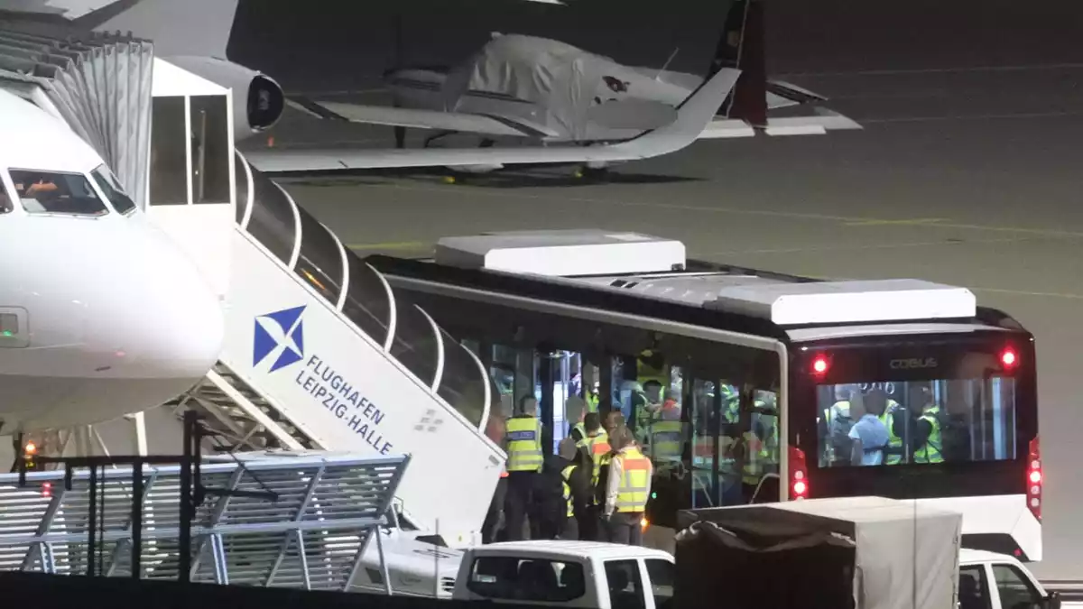 Mit einem Bus wurden die Männer zum Flugzeug gebracht. - Bild: Sebastian Willnow/dpa