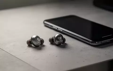 Hochwertige kabellose Ohrhörer liegen neben einem modernen Smartphone auf einem minimalistischen Schreibtisch. - Foto: über boerse-global.de