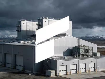Moderne Industriehalle in einer weitläufigen, kühlen Landschaft unter bewölktem Himmel. - Foto: über boerse-global.de
