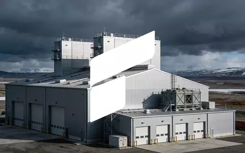 Moderne Industriehalle in einer weitläufigen, kühlen Landschaft unter bewölktem Himmel. - Foto: über boerse-global.de