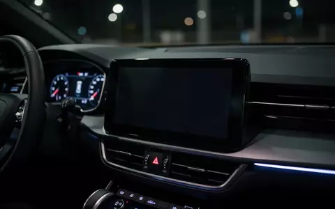 Ein dunkler, inaktiver Infotainment-Bildschirm im Armaturenbrett eines modernen Autos bei Nacht. - Foto: über boerse-global.de
