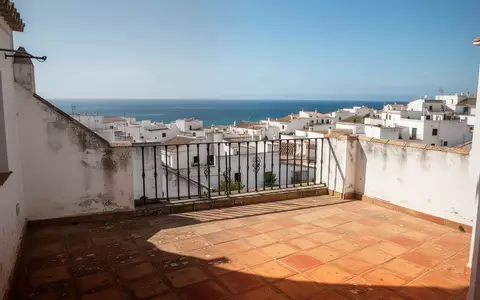 Ein leerer mediterraner Balkon mit Blick auf eine Küstenstadt in Spanien bei sonnigem Wetter. - Foto: über boerse-global.de