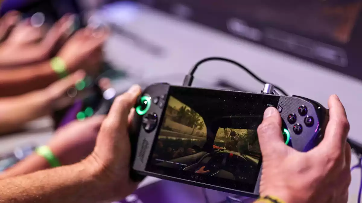Ein Gamer hält bei der Gamescom 2025 ein Handheld-Device - eine Art tragbaren Mini-Gamingcomputer - in den Händen. (Archivbild) - Bild: Oliver Berg/dpa
