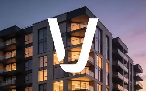 Moderne Wohnhausfassade bei Dämmerung mit leuchtenden Fenstern als Symbol für den Immobiliensektor. - Foto: über boerse-global.de