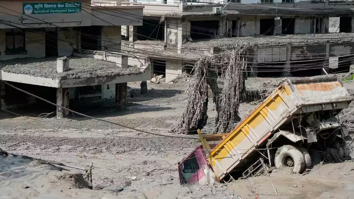 Ein Lkw versinkt in den Schlammmassen. - Bild: Niranjan Shrestha/AP/dpa