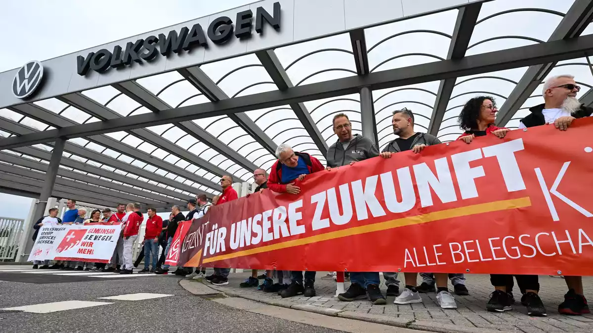 Vor der Betriebsversammlung von VW in Zwickau demonstrieren Beschäftigte am Werkstor.  - Bild: Hendrik Schmidt/dpa