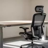 Ein minimalistisch eingerichteter, ergonomischer Arbeitsplatz mit einem höhenverstellbaren Schreibtisch und einem Bürostuhl. - Foto: über boerse-global.de