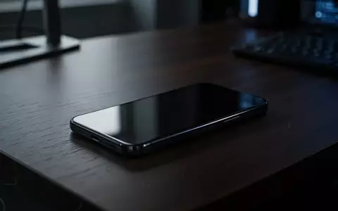 Ein dunkles Smartphone liegt auf einem Bürotisch, die Szene wirkt kühl und technisch und symbolisiert digitale Bedrohungen. - Foto: über boerse-global.de