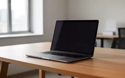 Ein minimalistischer Schreibtisch mit einem Laptop, dessen Bildschirm dunkel bleibt, in einer modernen Büroumgebung. - Foto: über boerse-global.de