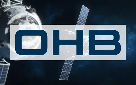 Ein technisches Satellitenbauteil vor einem dunklen Weltraumhintergrund, das die Luft- und Raumfahrtindustrie symbolisiert. - Foto: über boerse-global.de