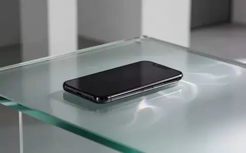 Ein modernes Smartphone auf einer mattierten Glasoberfläche mit sanften Lichtbrechungen in einer minimalistischen Umgebung. - Foto: über boerse-global.de