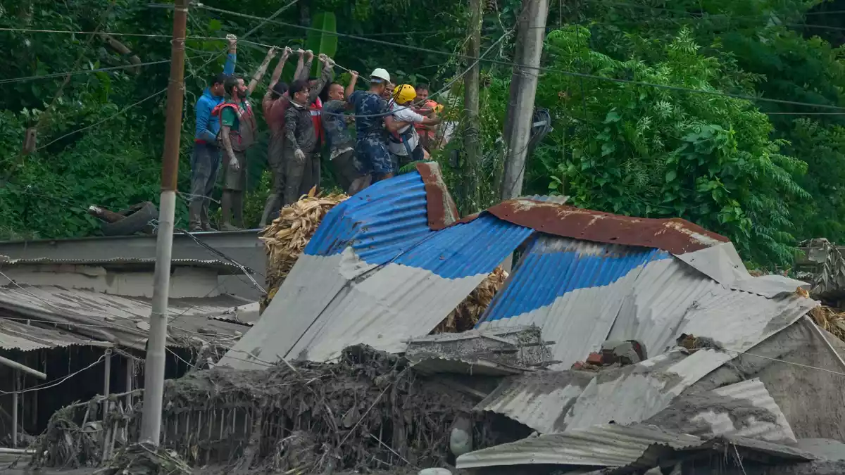 Rettungskräfte spannen ein Seil, um nach Überlebenden zu suchen, nachdem es im Bezirk Nuwakot in Nepal zu Sturzfluten entlang des Trishuli-Flusses gekommen ist. - Bild: Niranjan Shrestha/AP/dpa