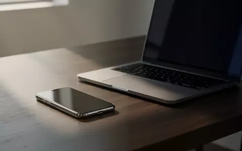 Ein modernes Smartphone liegt neben einem Laptop auf einem aufgeräumten Schreibtisch. - Foto: über boerse-global.de