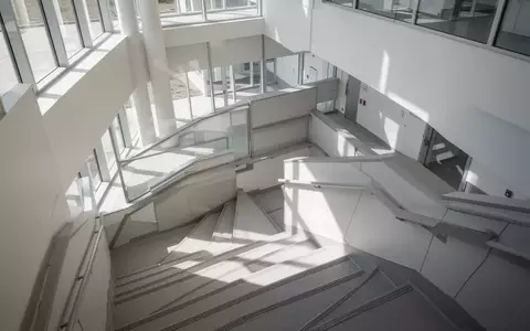 Ein minimalistisches, helles Treppenhaus in einem modernen Klinikgebäude mit klaren architektonischen Linien und natürlichem Licht. - Foto: über boerse-global.de