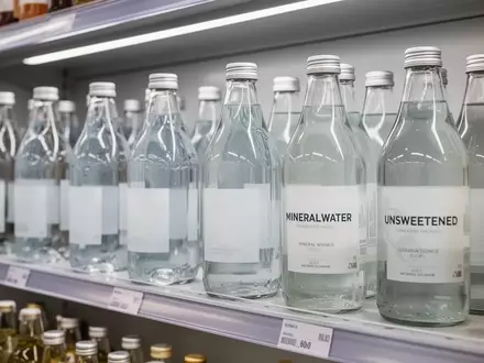 Regal mit verschiedenen Mineralwasserflaschen und ungesüßten Getränken in einem Supermarkt. - Foto: über boerse-global.de
