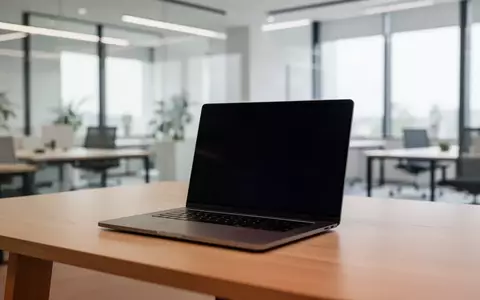 Ein minimalistischer Arbeitsplatz mit einem Laptop auf einem Holztisch in einem hellen, modernen BĂŒro. - Foto: ĂŒber boerse-global.de
