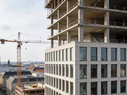 Halbfertiges Bürogebäude in einer deutschen Großstadt mit Baukran bei Tageslicht. - Foto: über boerse-global.de