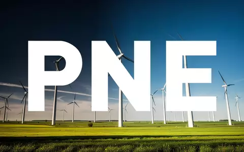 Moderne Windkraftanlagen in einer weitläufigen grünen Landschaft bei sonnigem Wetter als Symbol für erneuerbare Energien. - Foto: über boerse-global.de